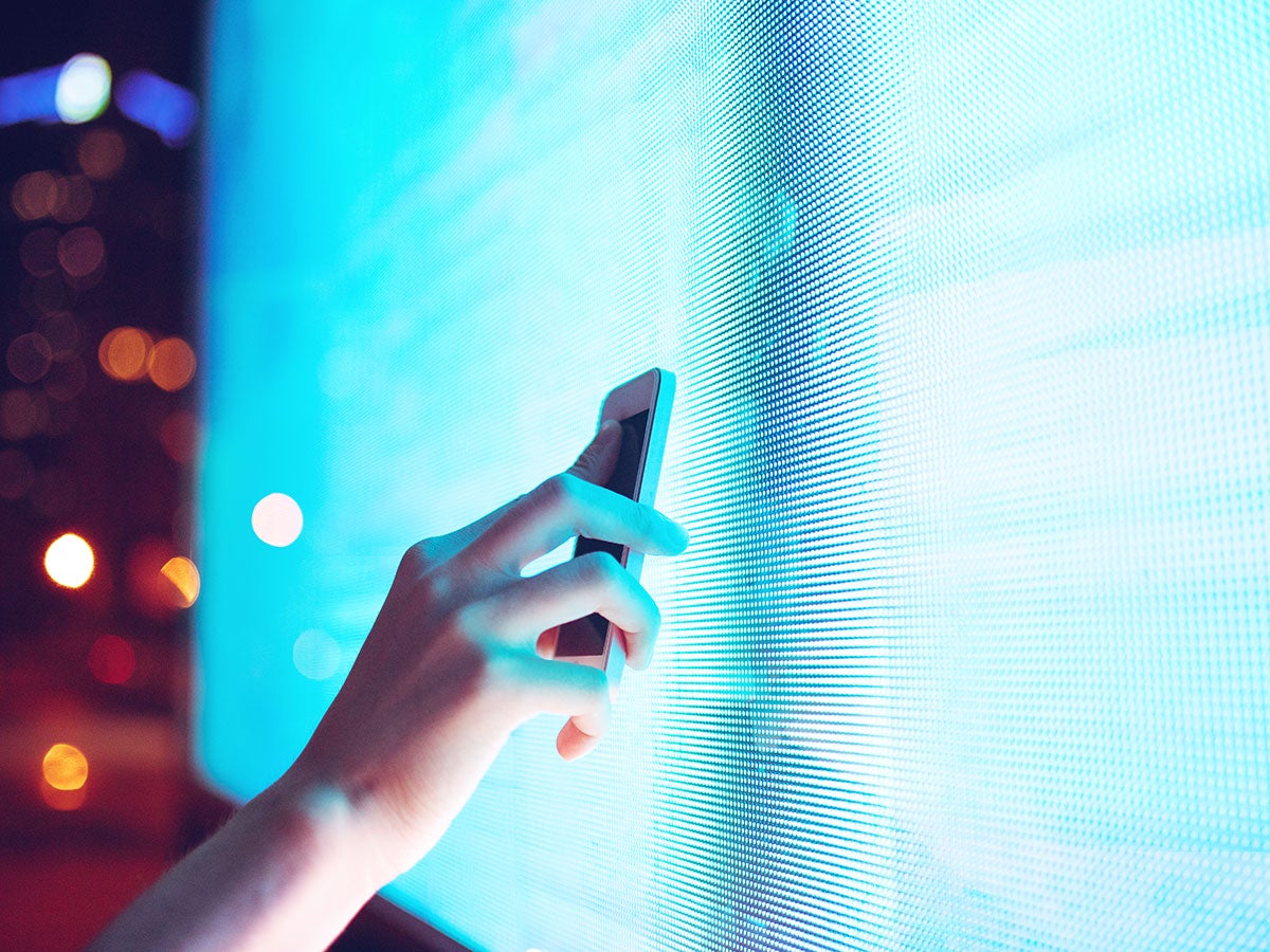 A person scanning a monitor with a cellphone