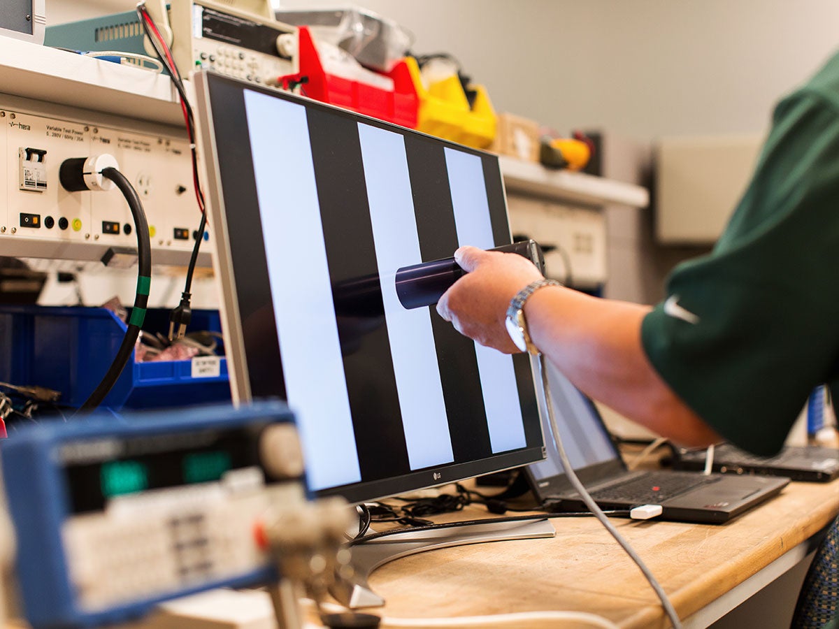 A person testing black and white bars on a monitor