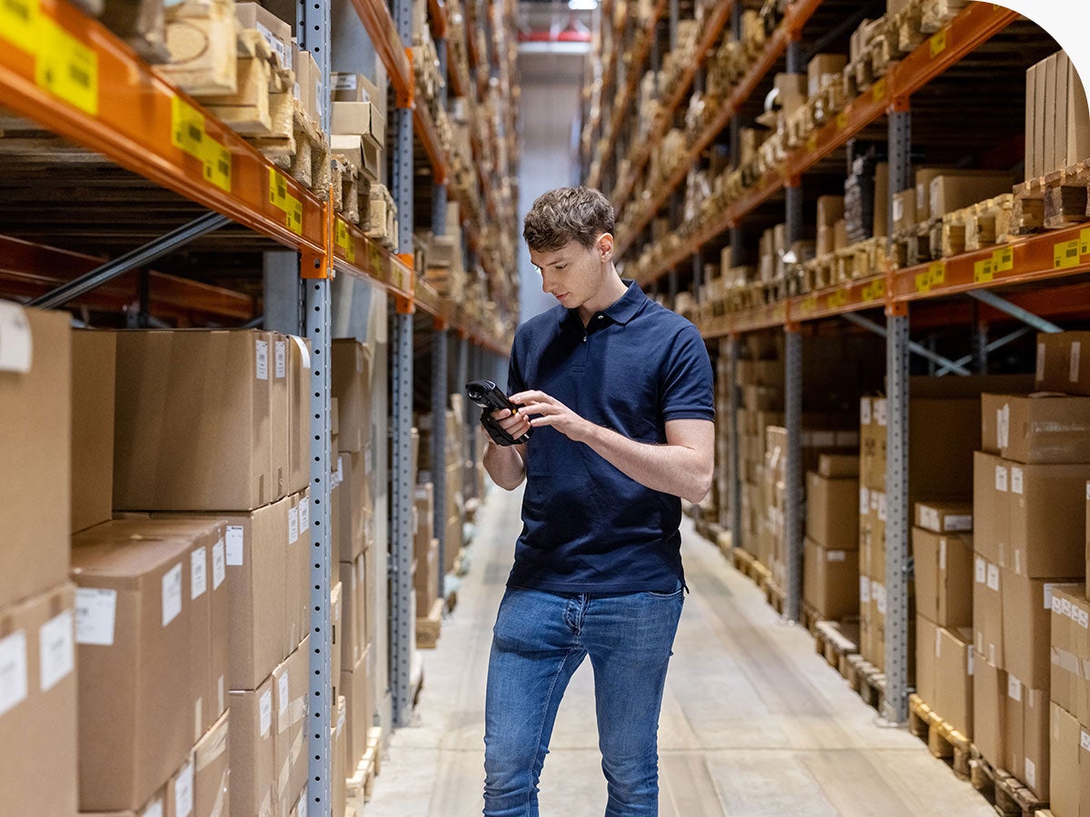 Person in a warehouse checking inventory with a scanner