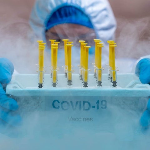 lab tech holding covid 19 vaccines with cold smoke