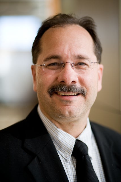 closeup photo of Kerry Bell in dark suit and tie. 