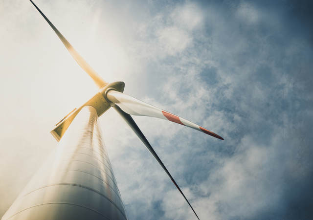 Looking up at a wind turbine