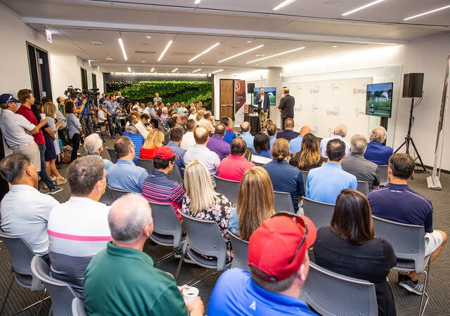 Photo of a crowd attending a presentation in a large view.