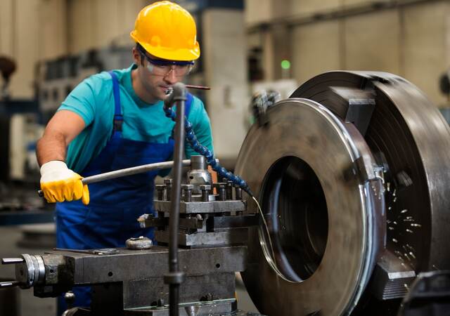 Man using metal cutting machine in factory