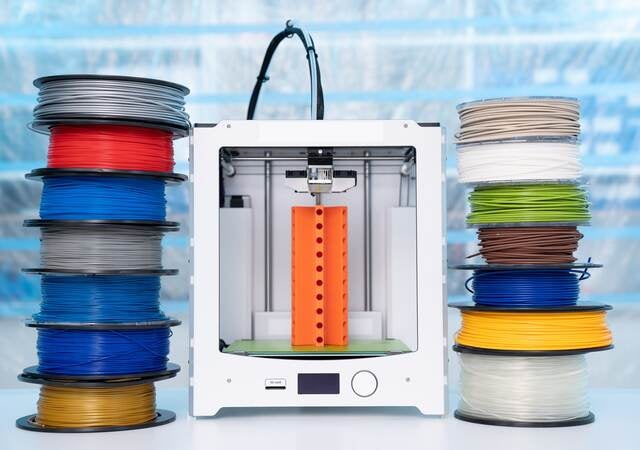 Spools of 3D printing filament and a 3D printer