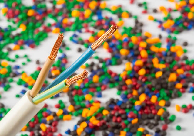 Plastic coated wire cable with plastic polymer granules in the background