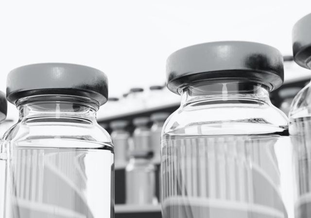 Low-angle photograph of vaccine vial in a freezer, surrounded by freezing fog