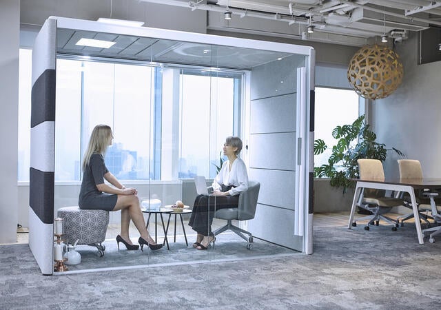 Office workers using a privacy booth