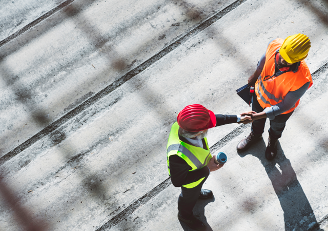 On a rooftop, two engineers are shaking hands