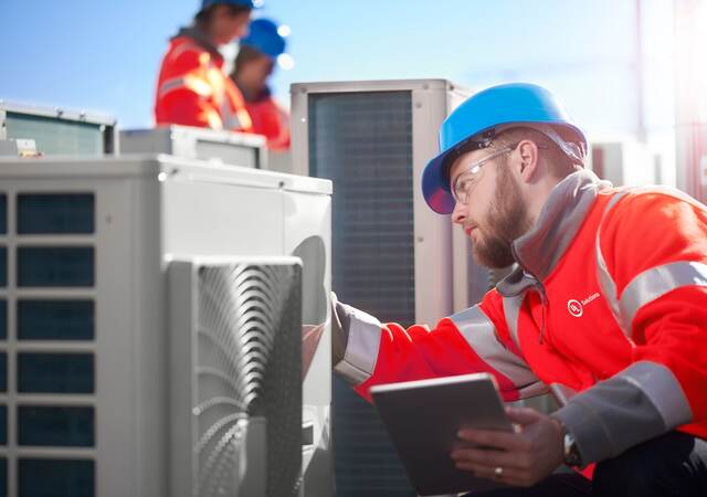 Man inspecting an outdoor unit of air conditioner