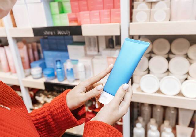 Person holding a bottle of cream at the store