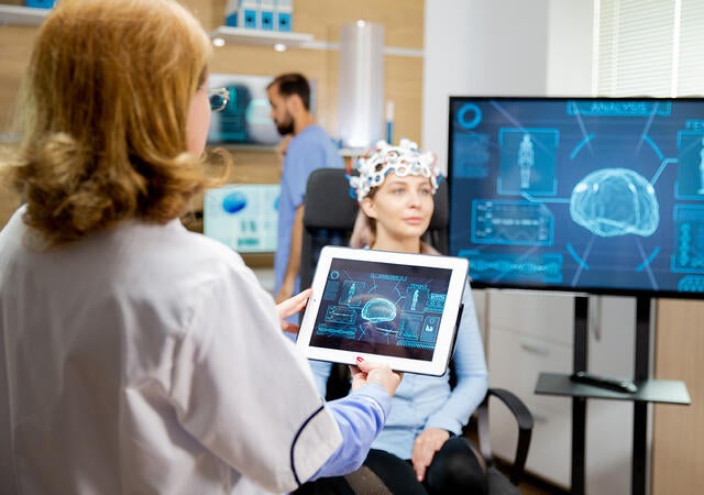 Woman in hospital setting wearing a brainwave monitor