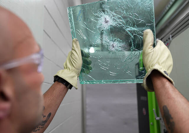 a person holding up bullet-proof glass