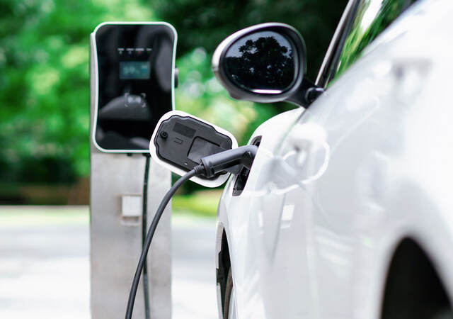 A white electric vehicle charging at a station