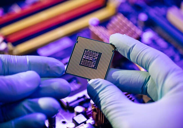 hands holding a computer chip