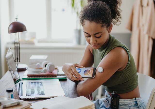 girl checking medical device on her phone