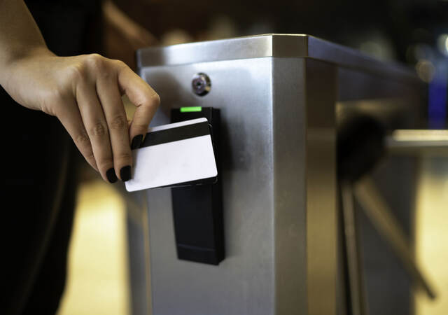 A person using a card reader at a turnstile