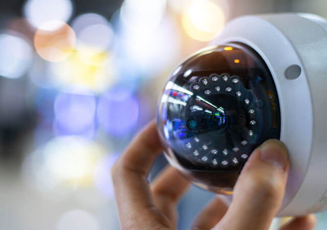 A person adjusting a security camera