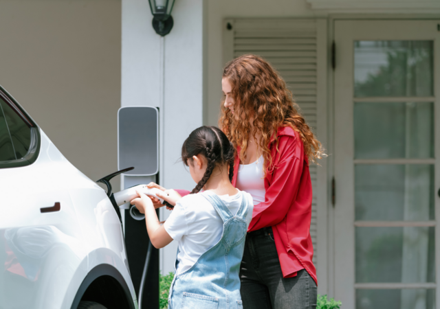 mother and daughter recharging EV at home