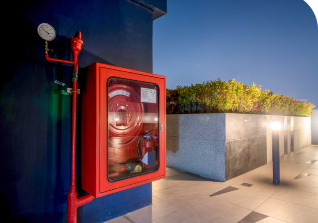 Fire prevention system on blue wall across from raised garden