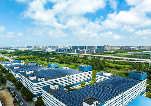 Aerial view of solar panels installed on factory rooftop