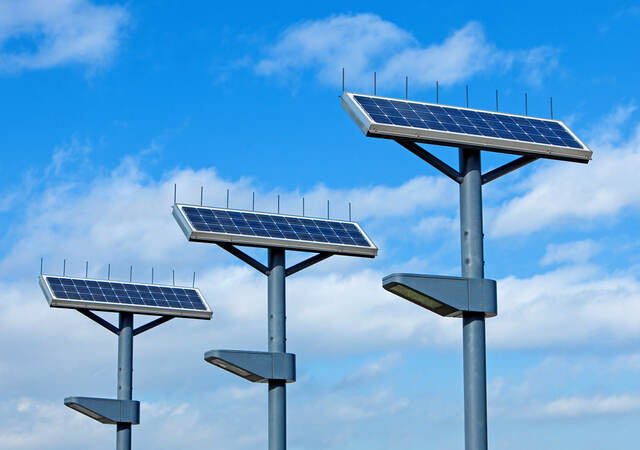 solar powered street lights shot against a blue sky