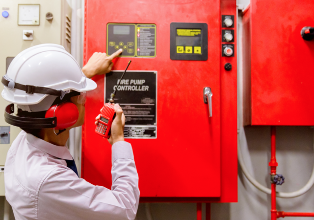 person in hard hat testing fire control system
