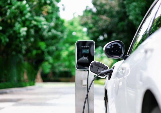 An electric vehicle charging at a charging station