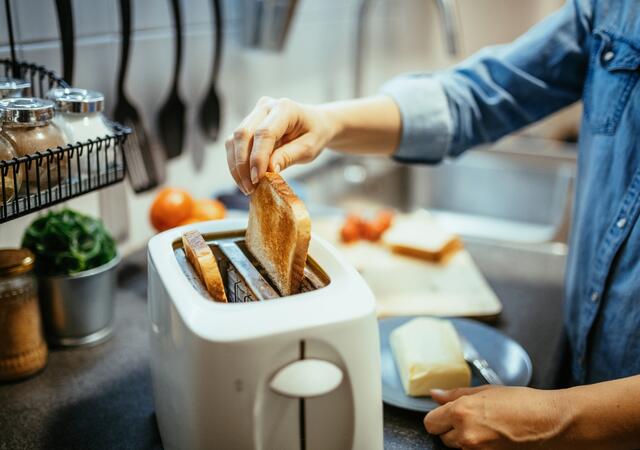 Person making toast in their kitchen