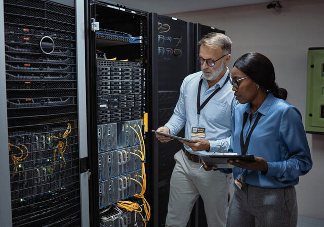 IT technicians fixing a computer system and network while doing maintenance in a datacenter