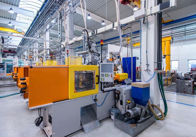 Orange and yellow machines in factory with motor