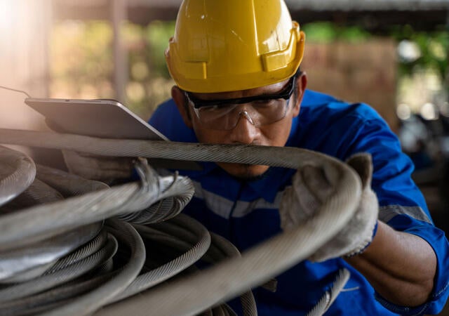 Engineer inspecting a wire cable