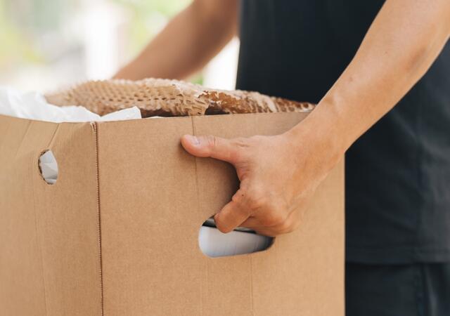A person holding a box of recycling