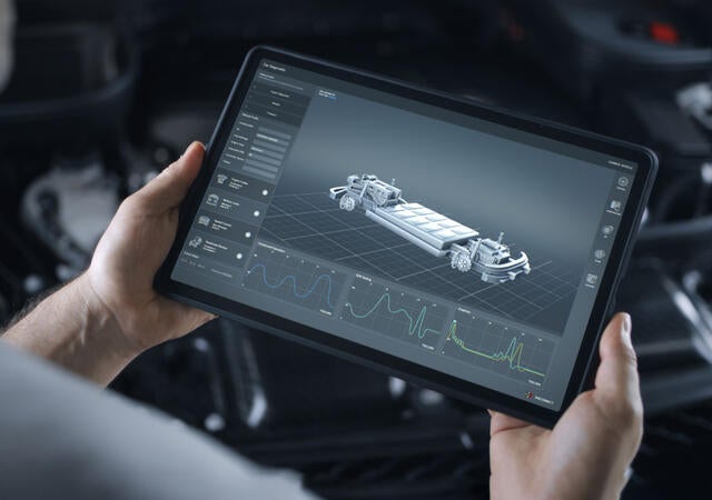 A person looking at an EV battery on a tablet
