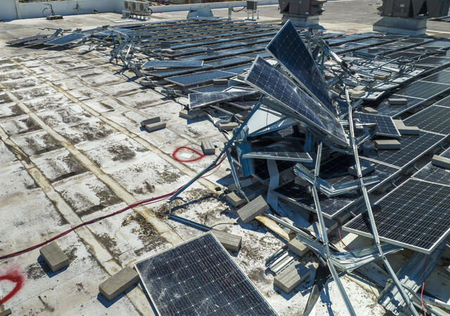 Destroyed solar panels on a roof after a storm