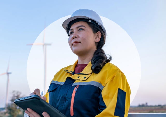A person in a hard hat, looking to the future