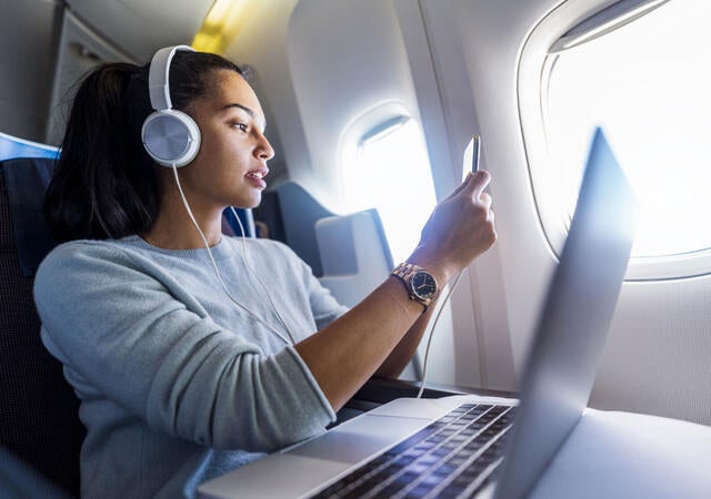 A person wearing headphones while on an airplane