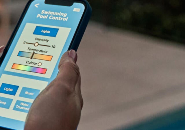 A person using a mobile device near a pool