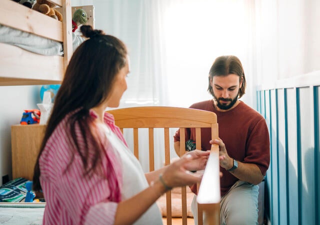 Two people building a crib