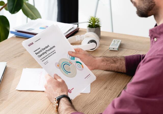 man reading the ComplianceWire training guide