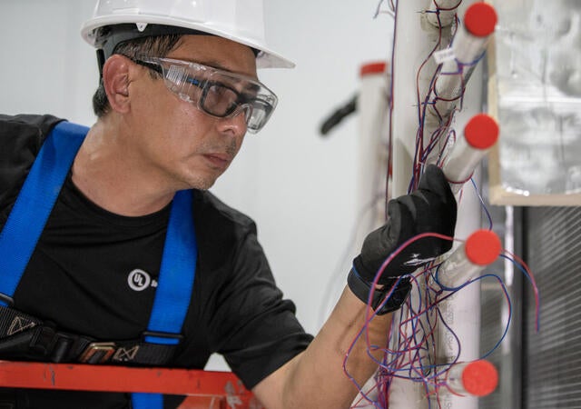 A tester working at the Plano HVAC laboratory