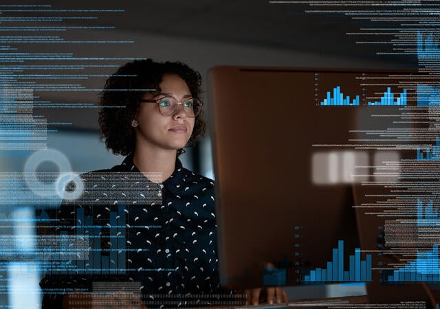 A person reviewing charts on a large monitor