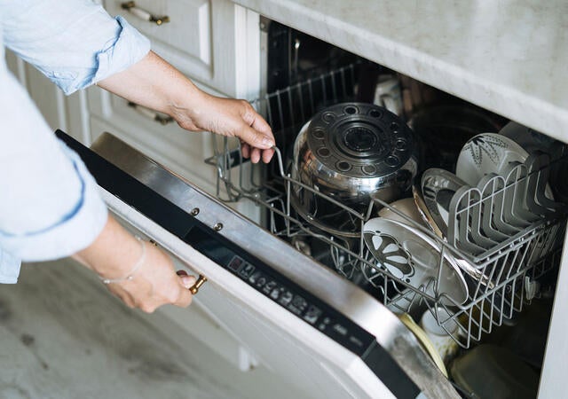 A person loading a dishwasher