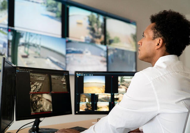 A security officer monitoring security footage on monitors