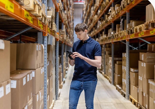Person in a warehouse checking inventory with a scanner