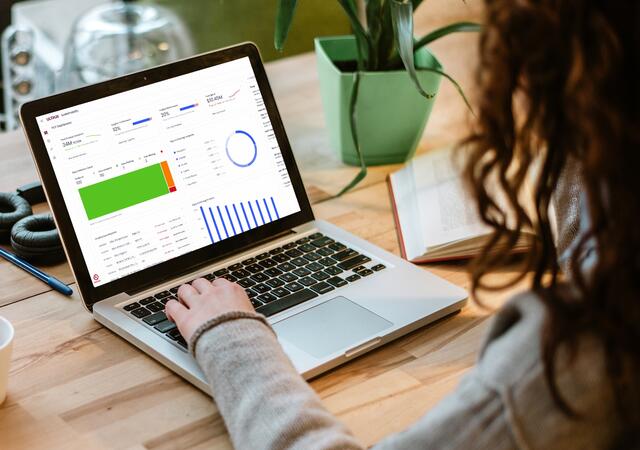 woman in office with laptop showing her organization's product carbon footprint