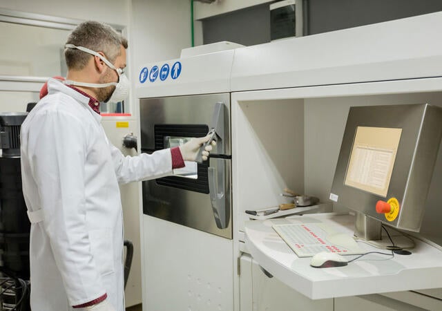 A person opening a 3D printer