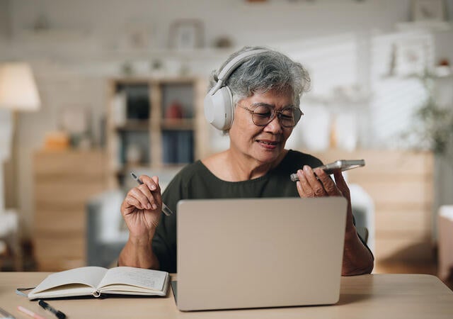 A person using a laptop and a mobile device