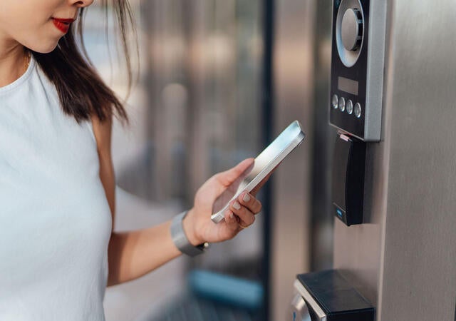 A person using a smart phone to scan a security device