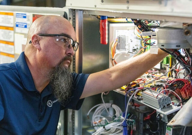 A Plano HVAC laboratory worker testing electrical